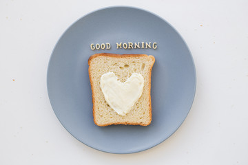 sandwich for breakfast in the form of heart with cheese on a blue plate inscription good morning
