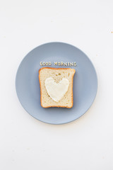 sandwich for breakfast in the form of heart with cheese on a blue plate inscription good morning