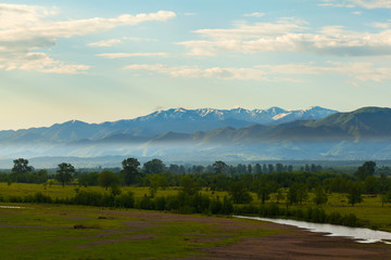 Fototapeta na wymiar Valley view from the river and the mountains in the background at sunrise. Georgia. Caucasus mountains