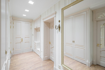 Hall in the flat. Wooden design, white colors. Wooden floor.