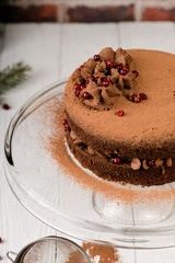 Chocolate cake with berries and cocoa powder on white wooden background. Authentic.
