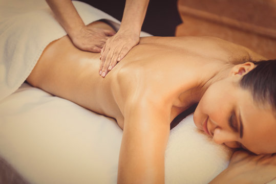 Skillful beautician massaging female body