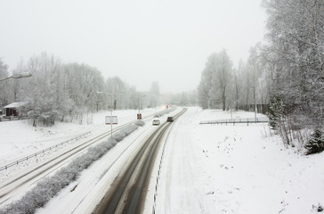 Obraz na płótnie Canvas Snowy road at gloomy winter day