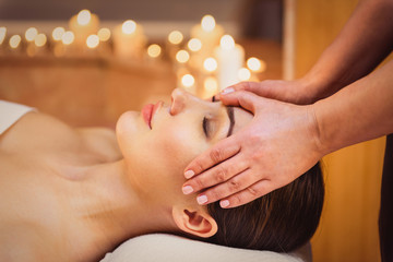 Serene girl getting facial massage at spa