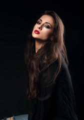 Naklejka premium Sexy female model with long brown hair posing in black shirt on