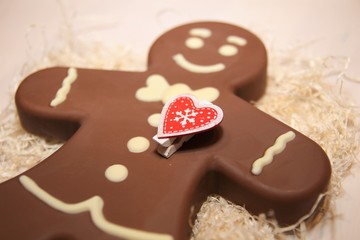 Figure  chocolate man decorated colored icing and being eaten. Holiday chocolate in shape of man for new year's day, christmas, winter holiday. Heart