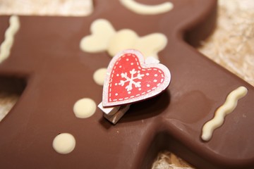 Figure  chocolate man decorated colored icing and being eaten. Holiday chocolate in shape of man for new year's day, christmas, winter holiday. Heart