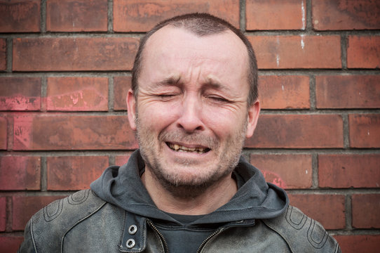 homme entrain de pleurer de dan un mur de briques, 