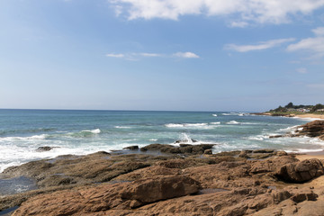 Fototapeta na wymiar Rocky Shoreline Against Ocean Sky Coastal Landscape