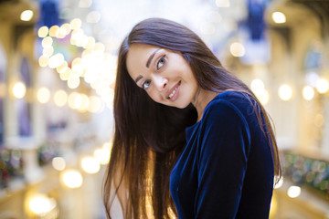 Young beautiful brunette woman in dark blue dress