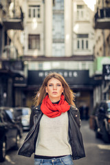 The model is on a side street and looking at the camera. Woman on the wind blows.