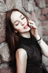 Fototapeta premium beautiful sad young woman on a stone wall background