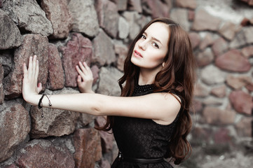 beautiful sad young woman on a stone wall background