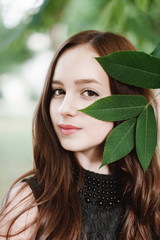 Fototapeta premium Beautiful young girl in black dress with long hair, super cute a