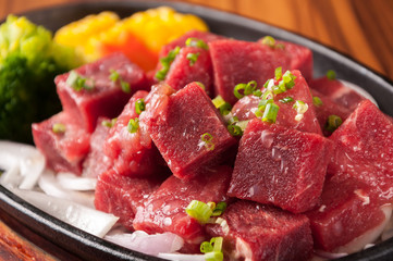 Raw cutting beef with vegetables on wooden plate