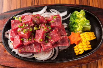 Raw cutting beef with vegetables on wooden plate