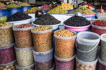  Markstand mit frischen Oliven in Plastikeimern abgefüllt und gestapelt auf dem Basar von Marrakesch Marokko  