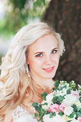 Beautiful bride. Wedding hairstyle and make up.Young bride in wedding dress holding bouquet