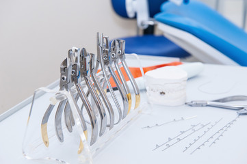 Close up Orthodontist Dental set of clamps and pliers and other tools on the working table surface