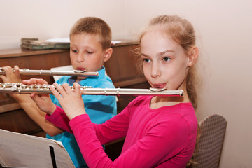 a boy and a girl playing the flute