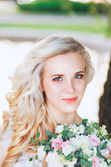 Naklejka premium Beautiful bride. Wedding hairstyle and make up.Young bride in wedding dress holding bouquet