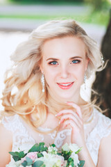 Fototapeta premium Beautiful bride. Wedding hairstyle and make up.Young bride in wedding dress holding bouquet