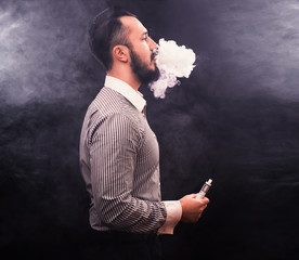 Men with beard vaping and releases a cloud of vapor.