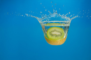 Kiwi splashing in water with blue background
