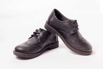 Black worn leather shoes on white background