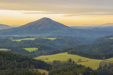 Hills and villages with foggy morning. Morning fall valley of Bohemian Switzerland park. 
