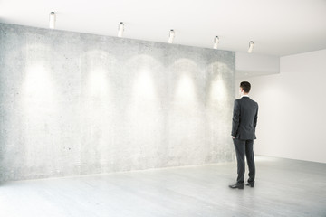 Businessman in room with empty wall side