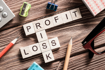 Profit loss and risk words on workplace collected of wooden cubes