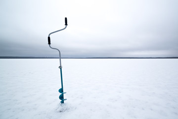 Winter fishing on ice in the middle of a frozen lake