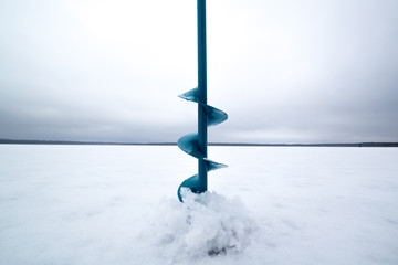 Winter fishing on ice in the middle of a frozen lake