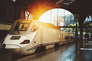 Modern contemporary white train with acuminate face at the station of Barcelona, Spain, sunny...