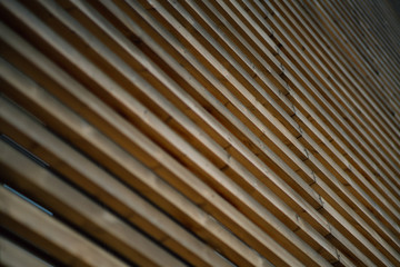 Close-up view of facade of modern building in Barcelona made by thick wooden stripes, sunny summer day, Spain