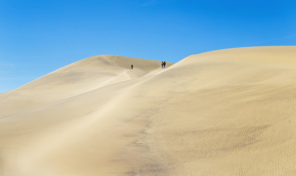 Tourists on the slope of the Dune 7 in Sossusvlei plato of Namib Naukluft National Park - Namibia, South-West Africa