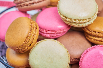 Colorful french macaroons in a heart shaped basket