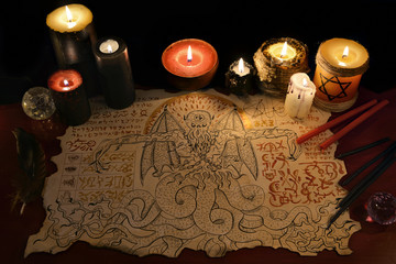 Black magic ritual with demon manuscript and evil candles