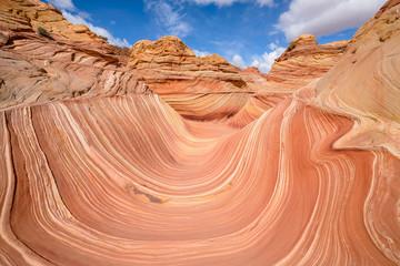 The Wave - Sunny midday view of The Wave, a dramatic erosional sandstone rock formation located in North Coyote Buttes area of Paria Canyon-Vermilion Cliffs Wilderness, at Arizona-Utah border.