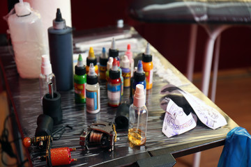 Tattoo master workplace with colorful inks and instruments, close up view