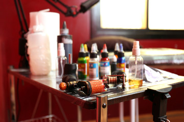 Parts of tattoo machine on wooden table, close up view