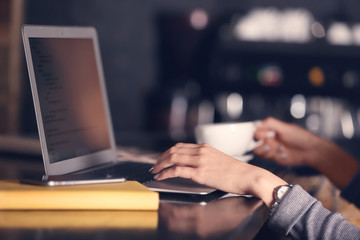Woman working with laptop in cafe