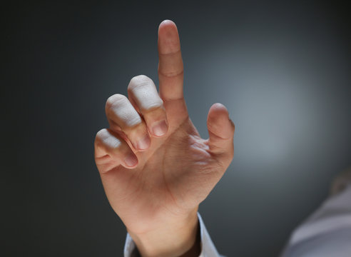 Businessman hand pointing, dark background