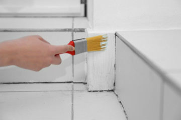 Young female worker making repair in room, closeup