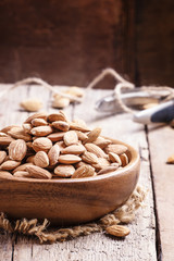Raw peeled almond, vintage wooden background, selective focus