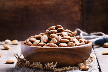 Raw peeled almond, vintage wooden background, selective focus
