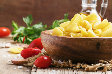 Castellane Dried pasta in a bowl, olive oil, tomatoes, garlic an