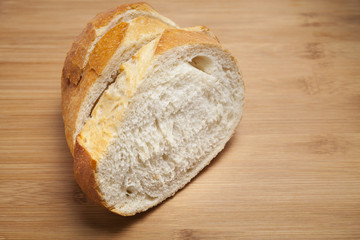 Three slices of French Bread on wooden cutting board.