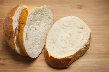 Three slices of French Bread on wooden cutting board.